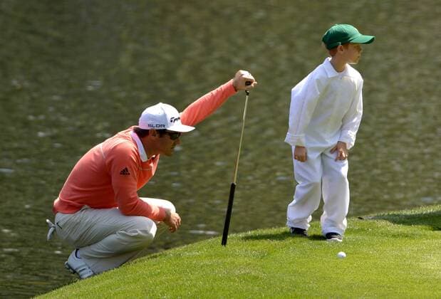 Trevor Immelman and his son Jacob line up a putt on the ninth green during the Par 3 Contest during the Masters Tournament at Augusta National Golf Club in Augusta, Georgia, April 8, 2014.  AUG20140409356