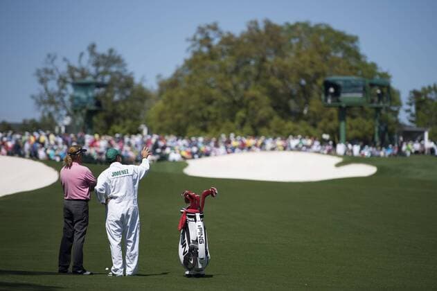 Miguel Angel Jimenez and his caddie Clifford Botha plan a shot on the 18th fairway during the first round of the 2014 Masters Tournament at Augusta National Golf Club in Augusta, Georgia, April 10, 2014.  AUG20140410363