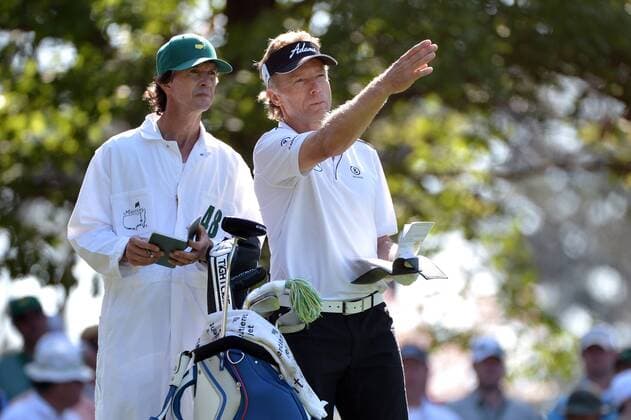 Bernhard Langer and his caddie Peter Coleman talk about a shot on the 4th tee during the second round of the 2014 Masters Tournament at Augusta National Golf Club in Augusta, Georgia, April 11, 2014. Watson finished seven under par.  AUG20140411335