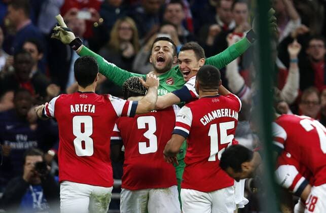 Lukasz Fabianski (Top), goalie of Arsenal, celebrates victory with teammates after FA Cup semifinal match between Arsenal FC and Wigan Athletic at Wembley Stadium in London, Britain, on April 12, 2014. (Xinhua Wang Lili) 