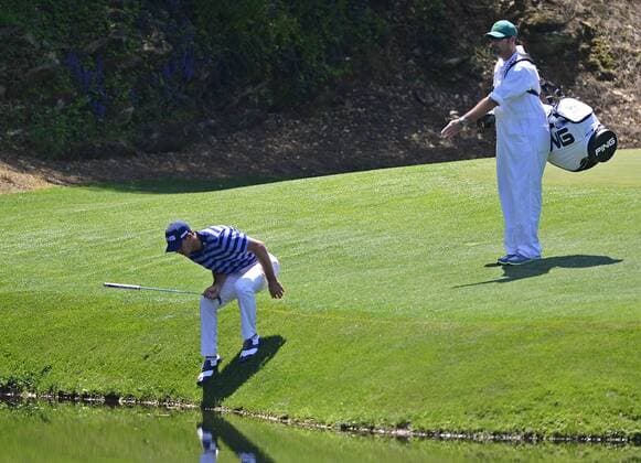April 12, 2014 - Augusta, GA, USA - Golfer Billy Horschel tries to locate Gary Woodland s golf ball in a stream at the 12th green as Horschel s caddie, Micah Fugitt, during the third round at the Masters Tournament in Augusta, Ga., Saturday, April 12, 2014. Masters Tournament - ZUMAm67