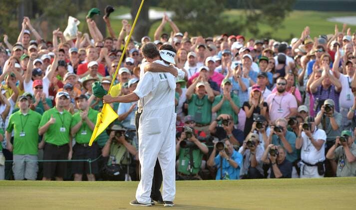 Bubba Watson hugs caddie Ted Scott on the 18th green in the final round round of the 2014 Masters Tournament at Augusta National Golf Club in Augusta, Georgia on April 13, 2014. Watson wins the Masters with a score of 8 under par.  AUG20140413351