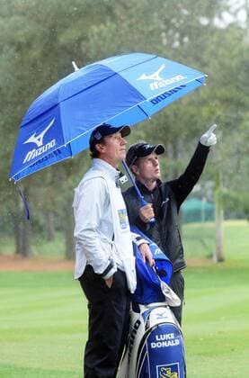 April 18, 2014 - Hilton Head Island, SC, USA - Luke Donald, right, and his caddy talk beneath their umbrella as they wait on the ninth fairway during the second round of the RBC Heritage Presented by Boeing at Harbour Town Golf Links in Sea Pines on Hilton Head Island, S.C., Friday, April 18, 2014. RBC Heritage Presented by Boeing - ZUMAm67