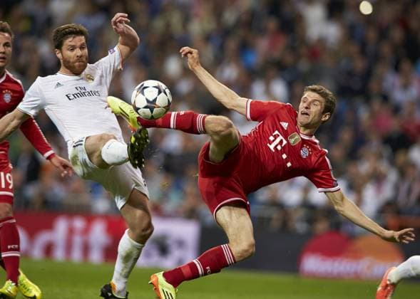 23.04.2014 Madrid, Spain. Midfielder Xabi Alonso of Real Madrid (L) duels for the ball with Thomas MÃ¼ller during the UEFA Champions League Game between Real Madrid and FC Bayern Munich at Santiago Bernabeu Stadium xIvanxArlandisx  ActionPlus11517770