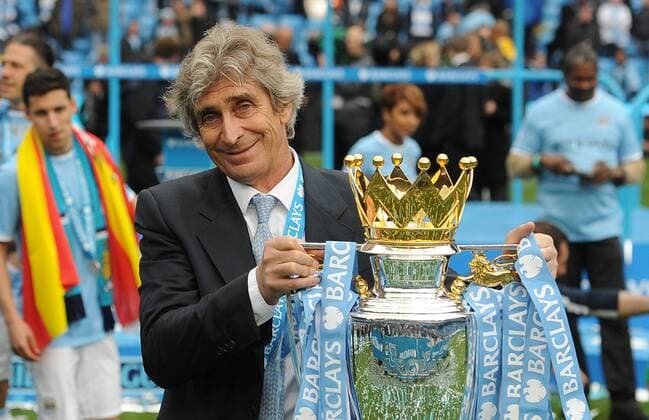 Football - 2013 2014 Premier League - Manchester City vs. West Ham United Manchester City s manager Manuel Pellegrini holds the Barclays Premier League trophy at the Etihad Stadium, Manchester 