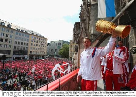 MUNICH, GERMANY - MAY 18: Manuel Neuer of Bayern München holds the German cup winners trophy as the team celebrate winning the German Championship title and the German Cup finale on the town hall balcony at Marienplatz on May 18, 2014 in Munich, Germany. Local Caption Manuel Neuer