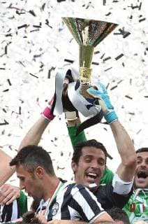 JUVENTUS, May 18, 2014 (Xinhua) -- Juventus Gianluigi Buffon (C) holds the trophy to celebrate victory after the Italian Serie A soccer match against Cagliari in Turin, Italy, May 18, 2014. Champions Juventus became the first team to break the 100-points barrier in Serie A when they beat Cagliari Calcio 3-0 in their final league game of the season on Sunday. (Xinhua Alberto Lingria) (SP)ITALY-JUVENTUS-SOCCER-SERIEA 