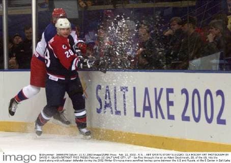 Feb. 22, 2002 - U.S. - KRT SPORTS STORY SLUGGED: OLY-HOCKEY KRT PHOTOGRAPH BY DAVID P. GILKEY DETROIT FREE PRESS (February 22) SALT LAKE CITY, UT - Ice flies throught the air as Adam Deadmarsh, 28, of the US, hits the board along with a Russian defender during the 2002 Winter Olympics mens semifinal hockey game between the U.S and Russia, at the E Center in Salt Lake City, Utah, Friday February 22, 2002. (DE) NC KD BL 2002 (Horiz) (Digital image) (smd) News Archive - Feb. 22, 2002 - ZUMAm67