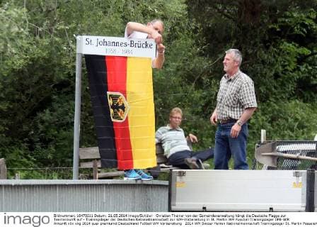 Christian Theiner von der Gemeindeverwaltung hängt die Deutsche Flagge zur Teamankunft auf - Trainingslager der Deutschen Nationalmannschaft zur WM-Vorbereitung in St. Martin