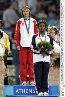 Aug. 21, 2004 - U.S. - KRT SPORTS STORY SLUGGED: OLY-TRACK KRT PHOTO BY RON CORTES PHILADELPHIA INQUIRER (August 22) ATHENS, GREECE -- Lauryn Williams, right, of the United States gets her silver medal in the 100 meters next to gold medalist Yuliya Nesterenko of Belarus at the 2004 Olympic Games on Sunday, August 22, 2004. (gsb) 2004 News Archive - Aug. 21, 2004 - ZUMAm67