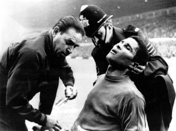 1966 World Cup Portugal v Hungary Eusebio receiving treatment from a physiotherapist, aided by a policeman, after a collision during the match. 13th July 1966, Polizei, Polizist, Polizeimann kbdig quer  UnitedArchives00598367