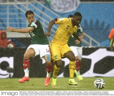 (140613) -- NATAL, June 13, 2014 (Xinhua) -- Mexico s Javier Hernandez (L) competes with Cameroon s Aurelien Chedjou during a Group A match between Mexico and Cameroon of 2014 FIFA World Cup at the Estadio das Dunas Stadium in Natal, Brazil, June 13, 2014. (Xinhua Lui Siu Wai)(pcy) (SP)BRAZIL-NATAL-WORLD CUP 2014-GROUP A-MEXICO VS CAMEROON 