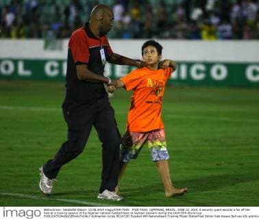 ITAR-TASS: CAMPINAS, BRAZIL. JUNE 13, 2014. A security guard escorts a fan off the field at a training session of the Nigerian national football team at Guarani Stadium during the 2014 FIFA World Cup.  Aufmacher kurios RE147297