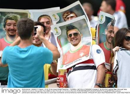 FUSSBALL WM 2014 VORRUNDE Gruppe G 16.06.2014 Lustige Idee: Portugal Fans schauen durch ein übergroßes Paninibild mit dem Portrait von Cristiano Ronaldo