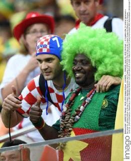 (140618) -- MANAUS, June 18, 2014 (Xinhua) -- A Croatia s fan (L) and a Cameroon s fan pose for photos before a Group A match between Cameroon and Croatia of 2014 FIFA World Cup at the Arena Amazonia Stadium in Manaus, June 18, 2014.(Xinhua Liu Dawei)(pcy) (SP) MANAUS-WORLD CUP 2014-GROUP A-FANS 