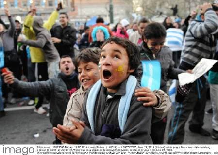 (140619) -- MONTEVIDEO, June 19, 2014 (Xinhua) -- Uruguay s fans cheer while watching a Group D match of 2014 FIFA World Cup on a screen in downtown Montevideo, capital of Uruguay, on June 19, 2014. (Xinhua NicolasxCelaya)(pcy) (SP)URUGUAY-MONTEVIDEO-WORLD CUP 2014-FANS 