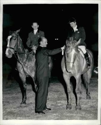 Jul. 24, 1956 - 24-7-56 Duke of Edinburgh presents a whip to Pat Smythe H.R.H. The Duke of Edinburgh last evening visited the International Horse Show at White City where he presented a presentation whip to each member of the British Show Jumping Team, Wilf White; Pat Smythe and Peter Robeson, who won the bronze medal at the recent Stockholm Equestrian Olympics. Keystone Photo Shows: The Duke of Edinburgh presents the whip to Pat Smythe at the White City while Wilf White looks on last evening.  - ZUMAk09