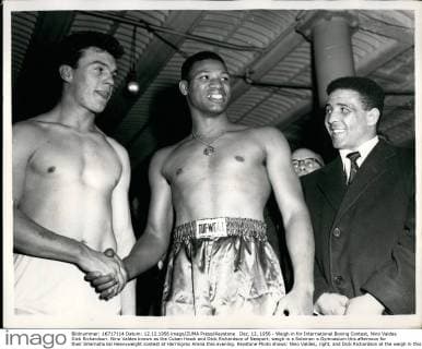 Großbritannien, Black History Month im Oktober - Sport Dec. 12, 1956 - Weigh in for International Boxing Contest, Nino Valdes Dick Richardson. Nino Valdes known as the Cuban Hawk and Dick Richardson of Newport, weigh in a Solomon s Gymnasium this afternoon for their International Heavyweight contest at Harringray Arena this evening. Keystone Photo shows: Nino Valdes, right, and Dick Richardson at the weigh in this afternoon and are both wished good luck by Randolph Turpin.  - ZUMAk09
