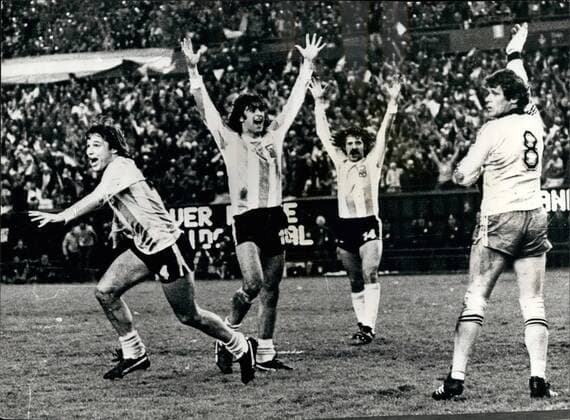 Argentina win the World Cup by beating Holland: The home nation Argentina won the World Cup at the River Plate Stadium in Buenos Aires when beating Holland by 3-1 after extra time. Photo shows Members of the Argentine team with their arms in the air after the final whistle, They are L-R Daniel Bertoni, Mario Kempes and Leopoldo Luque, the player on right, a member of the Dutch side.  - ZUMAk09