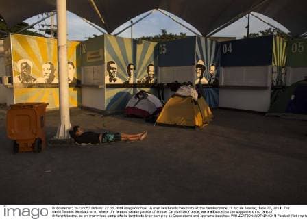 A man lies beside two tents at the Sambadrome, in Rio de Janeiro, June 27, 2014. The world famous Sambadrome, where the famous samba parade of annual Carnival take place, were allocated to the supporters and fans of different teams, as an improvised camp site to terminate their camping at Copacabana and Ipanema beaches. 
