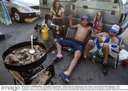 Football fans from Chile prepare their meal in a camp site at the Sambadrome, in Rio de Janeiro, June 27, 2014. The world famous Sambadrome, where the famous samba parade of annual Carnival take place, were allocated to the supporters and fans of different teams, as an improvised camp site to terminate their camping at Copacabana and Ipanema beaches. 