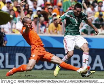 (140629) -- FORTALEZA, June 29, 2014 (Xinhua) -- Mexico s Hector Herrera vies with Netherlands s Ron Vlaar during a Round of 16 match between Netherlands and Mexico of 2014 FIFA World Cup at the Estadio Castelao Stadium in Fortaleza, Brazil, on June 29, 2014. (Xinhua Zhou Lei)(rh) (SP)BRAZIL-FORTALEZA-WORLD CUP 2014-ROUND OF 16-MEXICO VS NETHERLANDS 