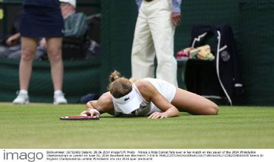 France s Alize Cornet falls over in her match on day seven of the 2014 Wimbledon Championships in London on June 30, 2014.Bouchard won the match 7-6 6-4.  LON2014063038