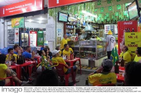 FUSSBALL WM 2014 VIERTELFINAL 04.07.2014 Brasilianische Fans schauen auf der Strasse vor einer Bar in Rio das WM Spiel; Brasilien im Fernsehen an.