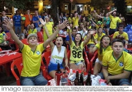 FUSSBALL WM 2014 VIERTELFINAL 04.07.2014 Brasilianische Fans schauen auf der Strasse vor einer Bar in Rio das WM Spiel; Brasilien im Fernsehen an.