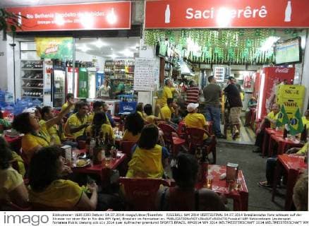FUSSBALL WM 2014 VIERTELFINAL 04.07.2014 Brasilianische Fans schauen auf der Strasse vor einer Bar in Rio das WM Spiel; Brasilien im Fernsehen an.