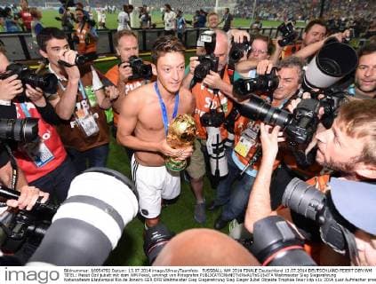 FUSSBALL WM 2014 FINALE Deutschland 13.07.2014 DEUTSCHLAND FEIERT DEN WM TITEL: Mesut Özil jubelt mit dem WM Pokal, umringt von Fotografen