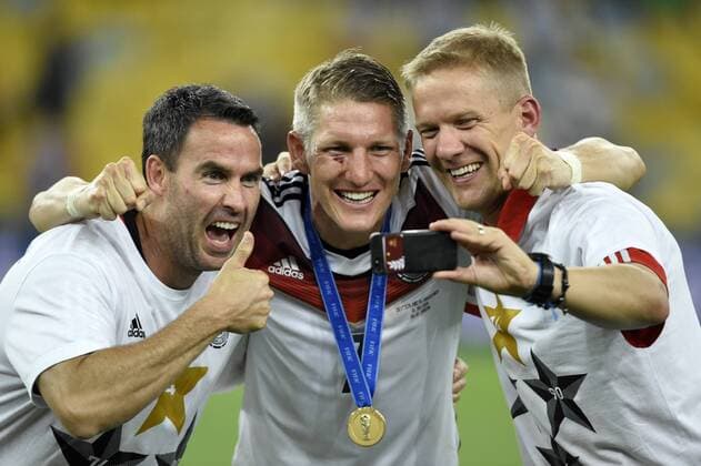 13.07.2014, Fussball WM 2014 - Finale: Deutschland - Argentinien in Rio de Janeiro, Maracana Stadion. Selfie nach der Siegerehrung, v.li: Shad Forsythe (Fitnesstrainer DFB), Bastian Schweinsteiger (Deutschland), und ein Betreuer machen ein Selbstportrait mit dem Handy. 