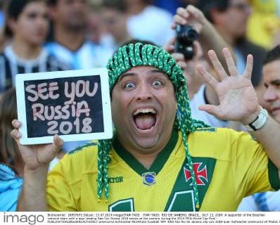 ITAR-TASS: RIO-DE-JANEIRO, BRAZIL. JULY 13, 2014. A supporter of the Brazilian national team with a sign reading See You Russia 2018 waves at the camera during the 2014 FIFA World Cup final -  premiumd Aufmacher RE14A1E2