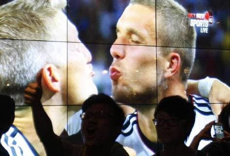 Shanghai - JULY 14:Fans of Germany national football team celebrate for Germany national football team with Bastian Schweinsteiger and Lukas Podolski an the screen winning the championship of the 2014 FIFA World Cup on July 14, 2014 in Shanghai. Germany national football team won the championship of the 2014 FIFA World Cup on July 14, and it is the fourth time that Germany national football team took the championship of the FIFA World Cup.  CFP3813 