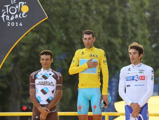 Runner up Jean-Christophe Peraud of France (L), winner Vincenzo Nibali of Italy and third-place finisher Thibaut Pinot of France arrive on the presentation podium after the Tour de France in Paris on July 27, 2014.  PAR201407127739