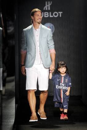 Zlatan Ibrahimovic of France s Paris Saint-Germain Football Club, left, walks with a little girl at a fashion show of Swiss watch brand Hublot during the Asia tour of the club in Hong Kong, China, 27 July 2014. Paris Saint-Germain football stars wow fans at watch fashion show in Hong Kong  20140727_30685