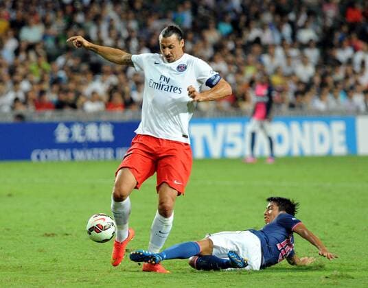 Zlatan Ibrahimovic (L) of Paris Saint-Germain (PSG) vies with Lam Ka Wai of Kitchee SC of Hong Kong during a friendly match in Hong Kong, China, July 29, 2014. (Xinhua LoxPing Fai) (SP) -FOOTBALL-FREINDLY 