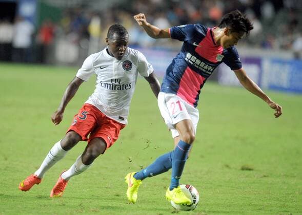 Hervin Ongenda (L) of Paris Saint-Germain (PSG) vies with Tsang Kam To of Kitchee SC of Hong Kong during a friendly match in Hong Kong, China, July 29, 2014. (Xinhua LoxPing Fai) (SP) -FOOTBALL-FREINDLY 