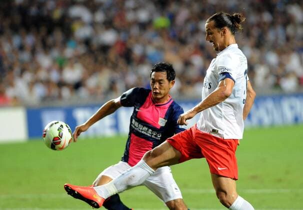 Zlatan Ibrahimovic of France s Paris Saint-Germain, front, challenges Jang Kyung-Jin of Hong Kong s Kitchee during their friendly football match in Hong Kong, China, 29 July 2014. Zlatan Ibrahimovic scored a hat-trick on Tuesday (29 July 2014) as Paris Saint-Germain enjoyed a 6-2 victory over Hong Kong outfit Kitchee. The 32-year-old had his shooting boots working for him and was ably supported by 21-year-old Jean-Christophe Bahebeck who scored his fifth and sixth goals of the pre-season so far. PSG now travel to Beijing in China which will host this season s French Super Cup between the Ligue 1 champions and surprise French Cup winners Guingamp. Zlatan Ibrahimovic scores hat-trick, leading Paris Saint-Germain to defeate Kitchee 6-2 at Hong Kong friendly match  20140729_33296