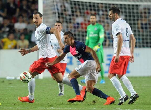 Zlatan Ibrahimovic of France s Paris Saint-Germain, left, challenges Juan Carlos Rodriguez Belencoso of Hong Kong s Kitchee, center, during their friendly football match in Hong Kong, China, 29 July 2014. Zlatan Ibrahimovic scored a hat-trick on Tuesday (29 July 2014) as Paris Saint-Germain enjoyed a 6-2 victory over Hong Kong outfit Kitchee. The 32-year-old had his shooting boots working for him and was ably supported by 21-year-old Jean-Christophe Bahebeck who scored his fifth and sixth goals of the pre-season so far. PSG now travel to Beijing in China which will host this season s French Super Cup between the Ligue 1 champions and surprise French Cup winners Guingamp. Zlatan Ibrahimovic scores hat-trick, leading Paris Saint-Germain to defeate Kitchee 6-2 at Hong Kong friendly match  20140729_33298