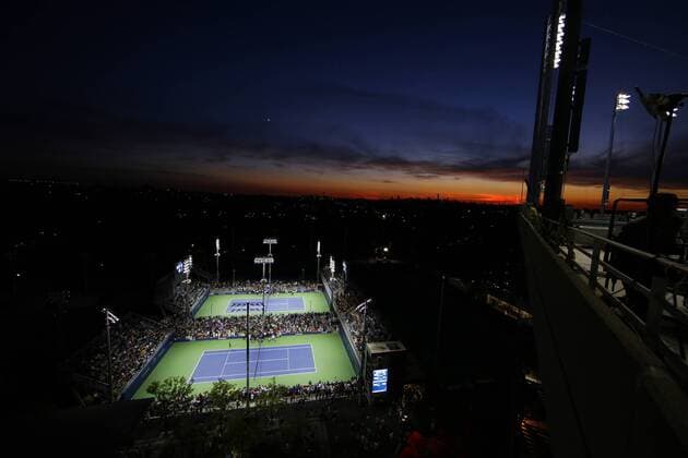 Fans watch tennis on the outer courts from the view at the top of Arthur Ashe Stadium at sunset at the US Open Tennis Championships at the USTA Billie Jean King National Tennis Center in New York City on August 29, 2014.  NYP20140829130