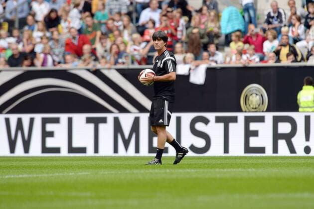Deutschland Training --- Fussball --- International --- 01.09.2014 Joachim Jogi Löw, Loew (Trainer Deutschland), mit einem Fussball in der Hand, im Hintergrund der Schriftzug Weltmeister, Freisteller, Einzelbild, Feature