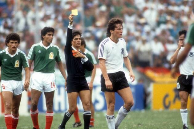 FIFA Schiedsrichter Jesus Diaz Palacio (Kolumbien) zeigt Lothar Matthäus (BR Deutschland) die gelbe Karte, daneben Francisco Cruz (li.) und Felix Cruz (beide Mexiko)