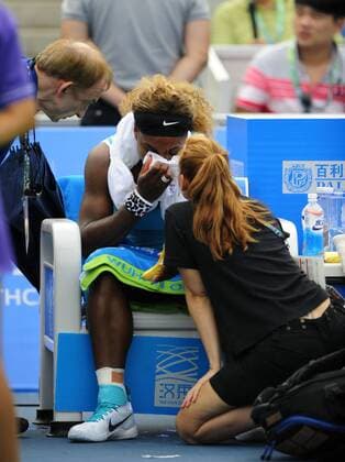 Serena Williams (C) of the United States receives treatment beside the court during the Women s singles match at the WTA Tennis Damen Wuhan Open tennis tournament in Wuhan capital of central China s Hubei Province, on Sept. 23, 2014. ) (djj) (SP)CHINA-WUHAN-TENNIS-WUHAN OPEN-WILLIAMS HaoxTongqian 