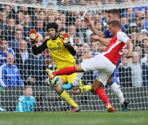 Chelsea s Petr Cech saves from Arsenal s Lukas Podolski - Barclays Premier League - Chelsea Vs Arsenal - Stamford Bridge - England - 5th October 2014 - EDITORIAL USE ONLY. No use with unauthorised audio, video, data, fixture lists, club league logos or live services. Online in-match use limited to 120 images, no video emulation. No use in betting, games or single club league player publications.