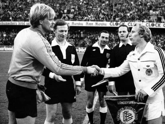 Schweden - BR Deutschland in Stockholm: Die Mannschaftskapitäne Ronnie Hellström (li., Schweden) und Berti Vogts (BRD) begrüßen sich, hi.li.: Schiedsrichter Kenneth Burns