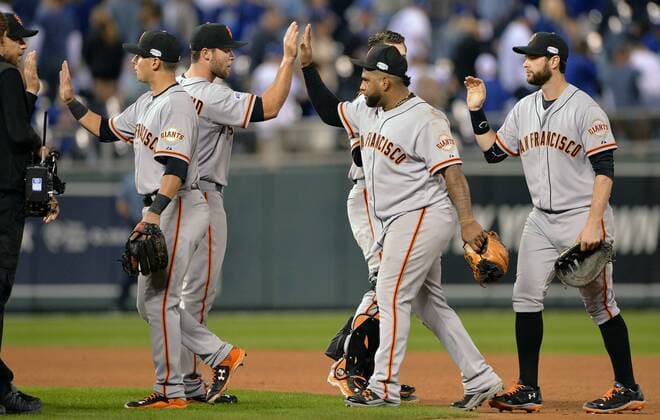 San Francisco Giants reliever Hunter Strickland (second from left) and third baseman Pablo Sandoval high five after defeating the Kansas City Royals in game 1 of the World Series at Kaufman Stadium in Kansas City, Missouri on October 21, 2014. The visiting Giants beat the Royals 7-1 to a take a 1-0 series lead.  KCP2014102168