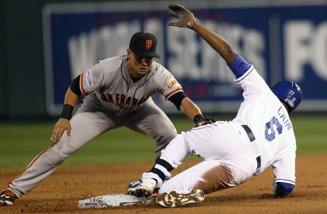 Kansas City Royals center fielder Lorenzo Cain reaches second base ahead of tag from San Francisco Giants second baseman Joe Panik for a double during the first inning of game 2 of the World Series at Kaufman Stadium in Kansas City, Missouri on October 22, 2014. San Francisco leads the series 1-0 over Kansas City.  KCP2014102223