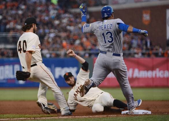 San Francisco Giants first baeman Brandon Belt (C) touches first base ahead of Kansas City Royals catcher Salvador Perez to make the put during the fourth inning in game 5 of the World Series at AT&T Park in San Francisco on October 26, 2014. The Royals and Giants are tied 2-2 in the series.  SXP2014102626