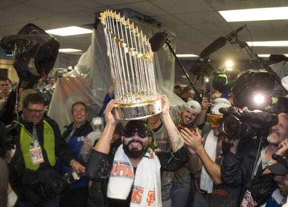 San Francisco Giants Sergio Romo celebrates with the Commissioner Trophy after the Giants won the 2014 World Series, defeating the Kansas City Royals at Kaufman Stadium in Kansas City, Missouri on October 28, 2014.  WAP20141029302